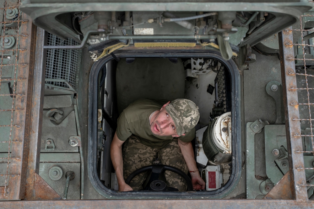 A service member Ukrainian Armed Forces sits inside an armoured personnel carrier, in Donetsk region. — Reuters