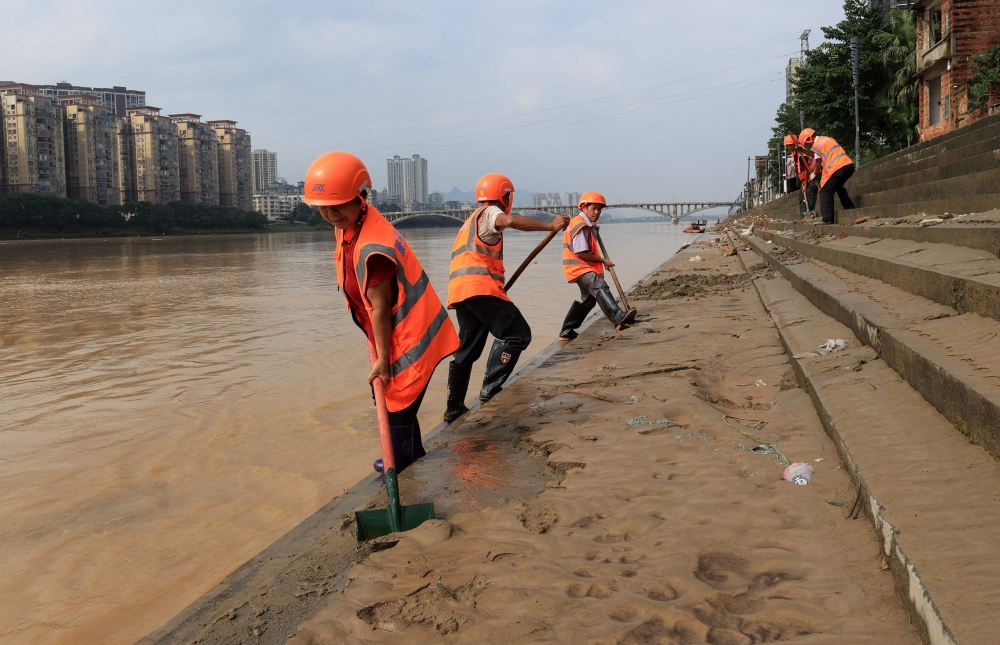 TOPSHOT - Workers clean up mud after flood waters subsided in Liuzhou, in China痴 southwest Guangxi region on June 25, 2025. China OUT
 (Photo by AFP)

