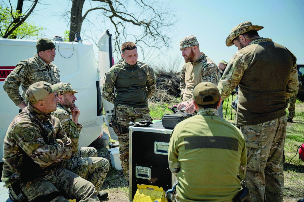 Sappers talk to each other before operating in a minefield near the village of Zaliman, in Kharkiv. — AFP