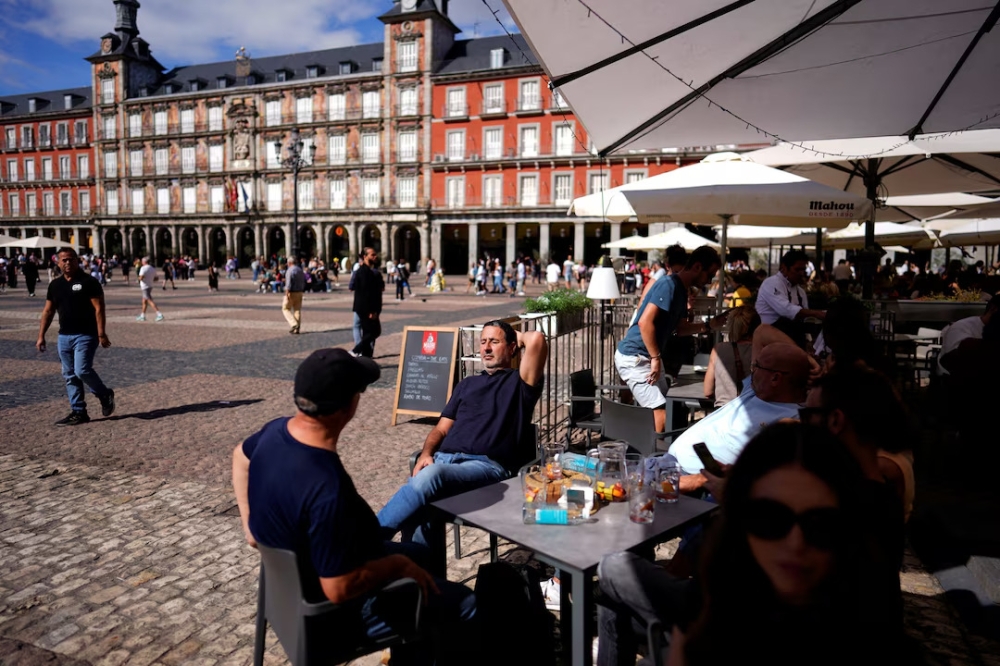 People spend time at a restaurant in Plaza Mayor in Madrid, Spain. — Reuters