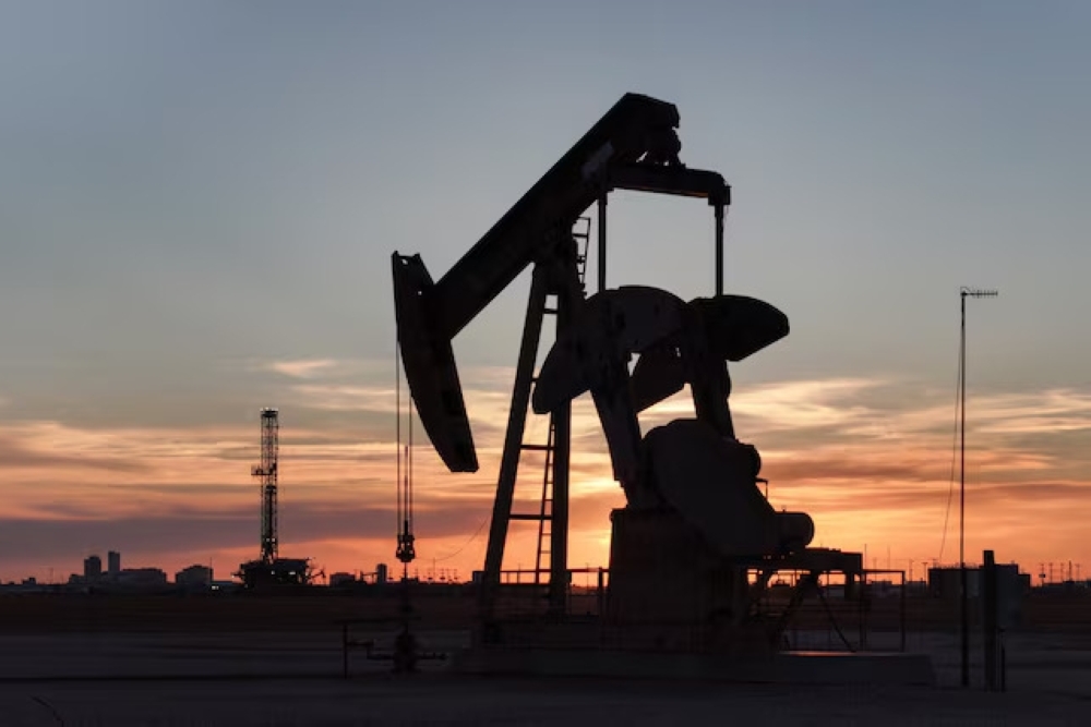 A drone view of a pump jack and drilling rig south of Midland, Texas, US. — Reuters