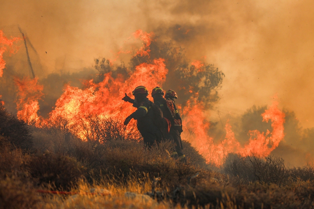 Firemen battle with a wildfire that broke out in Ierapetra at the southern Greek island of Crete. — AFP