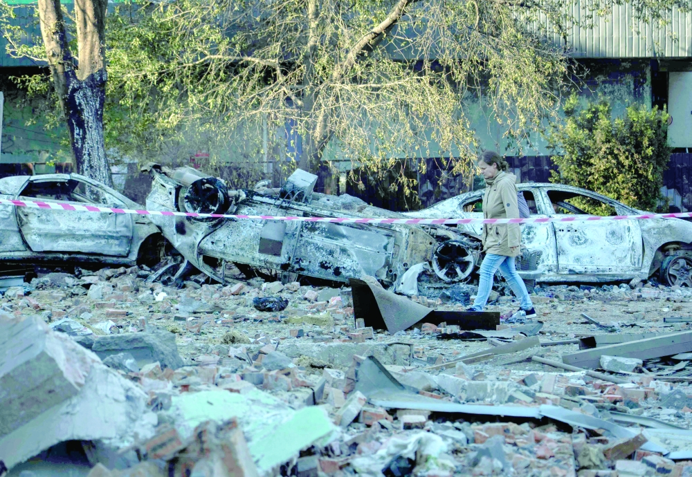 A woman makes her way through debris following mass Russian drone and missile strikes on Ukraine's capital Kyiv. — AFP