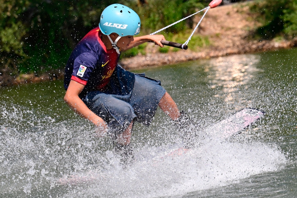 A person practises wakeboarding at a water sports leisure centre in Basse-Ham, north-eastern France, on July 2, 2025, as a heatwave hits Europe.  (Photo by Jean-Christophe VERHAEGEN / AFP)

