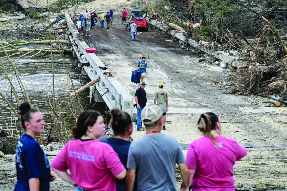 People look on as law enforcement and volunteers continue to search for missing people, in Hunt. — AFP