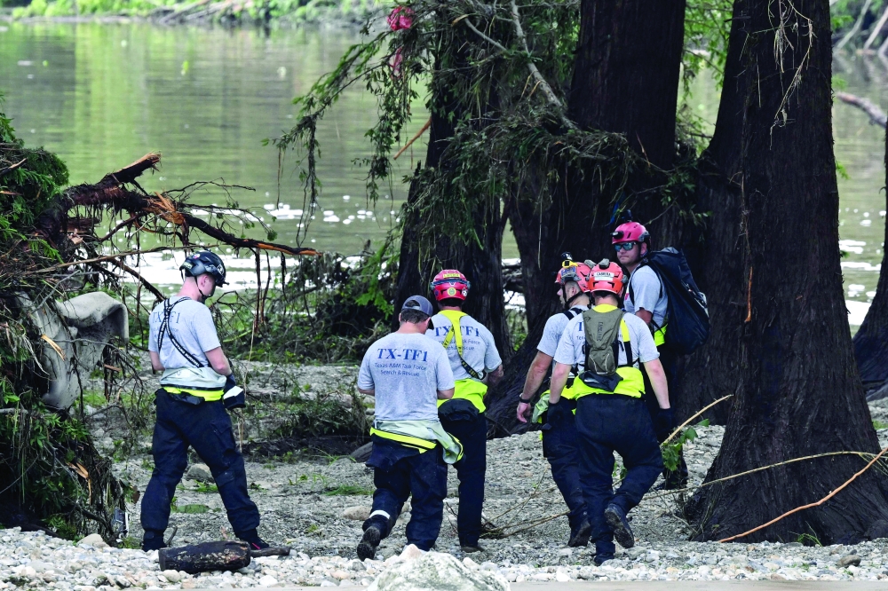 Members of a search and rescue team look for people near Camp Mystic, in Hunt. — AFP