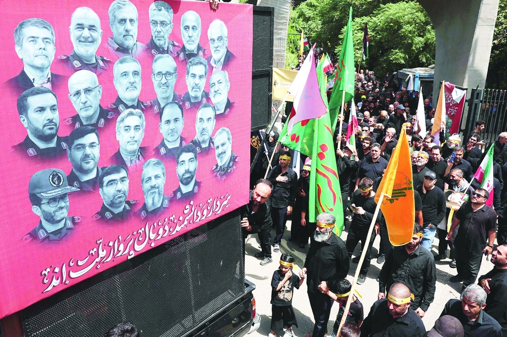 A poster bearing the portraits of scientists and military commanders killed. - AFP