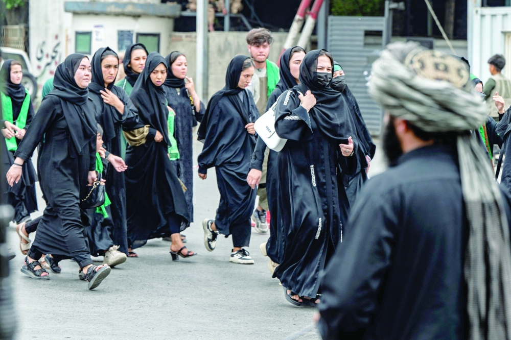 A Taliban security personnel stands guard as Afghan women march during a religious procession in Kabul. — AFP