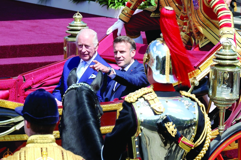 Britain's King Charles III and France's President Emmanuel Macron travel during a carriage precession at Windsor Castle in Windsor west of London. — AFP 