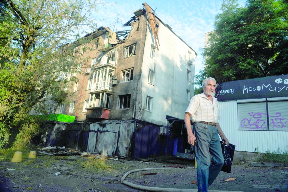 A man walks past a damaged residential building following a major overnight Russian attack in Kyiv amid the Russian invasion of Ukraine. - AFP