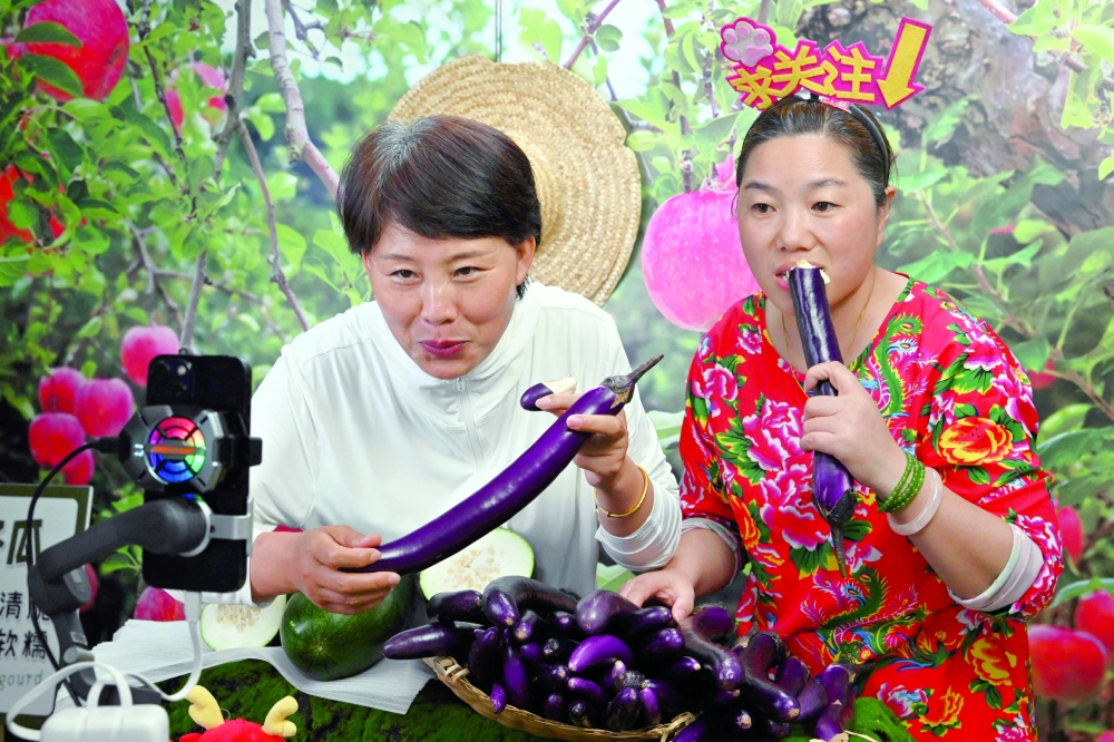 Participants of a 'hands-on livestreaming bootcamp' for farmers conducting a livestream sales presentation at the rural revitalisation office in Penglai, Yantai city, China's eastern Shandong province. - AFP