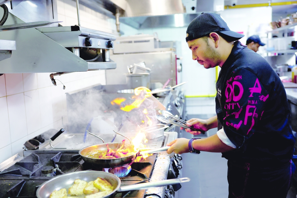 Chef Khimraj Nepali prepares a dish using the recipe from 'Aiman', the AI Chef, at the Trove Restaurant in Dubai. - Reuters