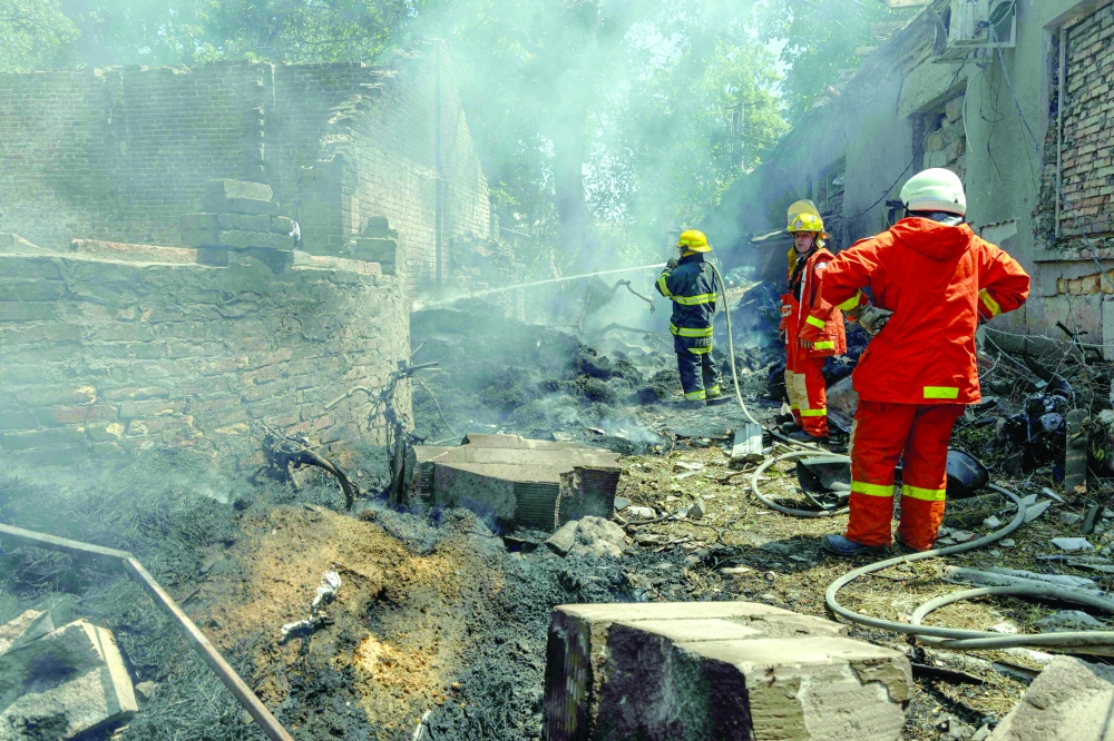 Ukrainian firefighters work to extinguish a fire in neighbouring residential houses, in Odesa. — AFP