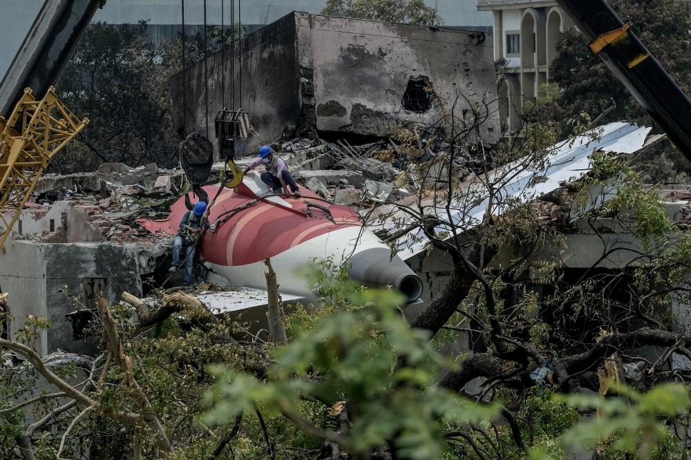 Workers prepare to hoist the tail section wreckage of Air India Flight 171, which crashed on June 12, in Ahmedabad, India, June 14, 2025. (Atul Loke/The New York Times)