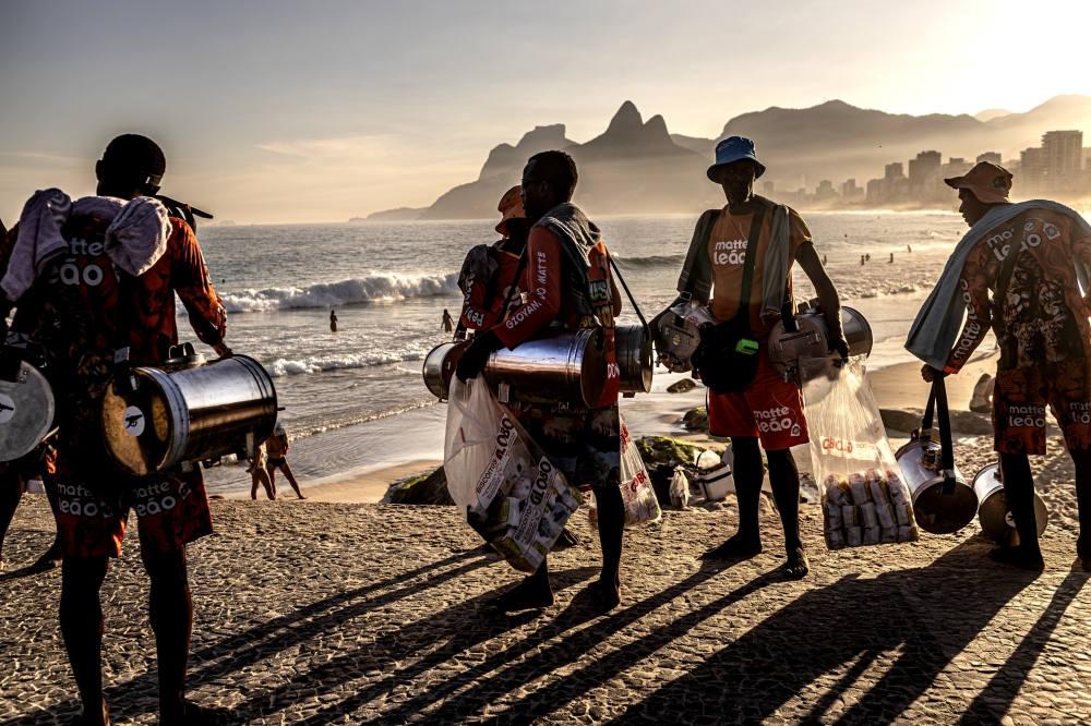 Several sellers of maté, or iced tea, at Arpoador Beach in Rio de Janeiro, June 4, 2025. (Dado Galdieri/The New York Times)
