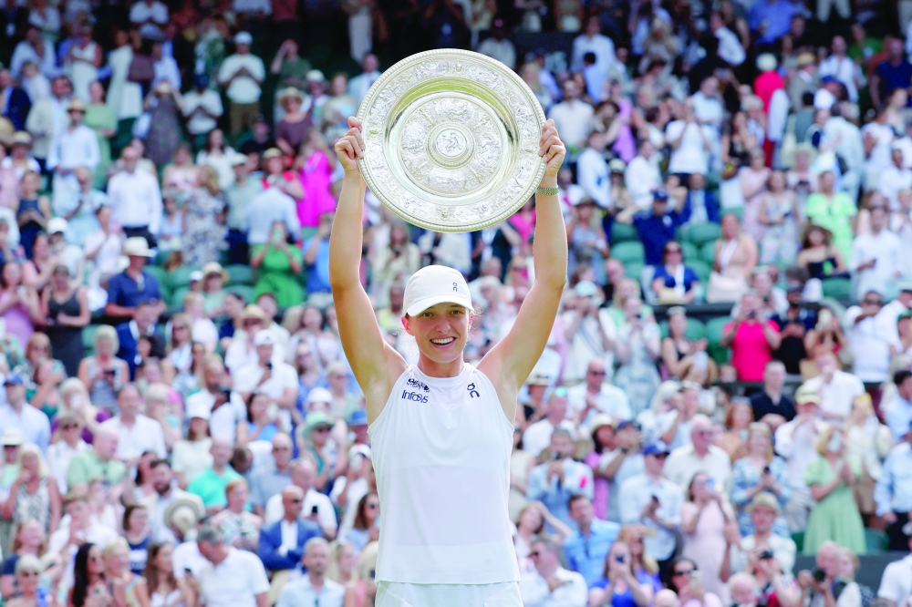 Poland's Iga Swiatek celebrates with the trophy after winning the women's singles final at Wimbledon against Amanda Anisimova of the U.S. 