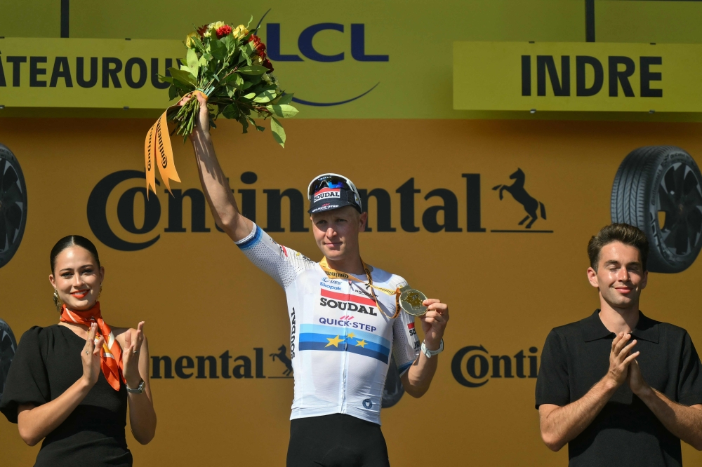 Soudal Quick-Step team's Belgian rider Tim Merlier celebrates on the podium after winning the 9th stage of the 112th edition of the Tour de France cycling race, 174.1 km between Chinon and Chateauroux, central France, on July 13, 2025. (Photo by Marco BERTORELLO / AFP)
