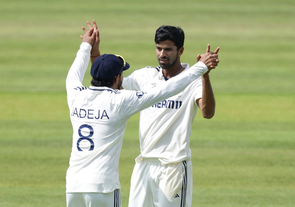 Washington Sundar celebrates with Ravindra Jadeja after taking the wicket of England's Joe Root.