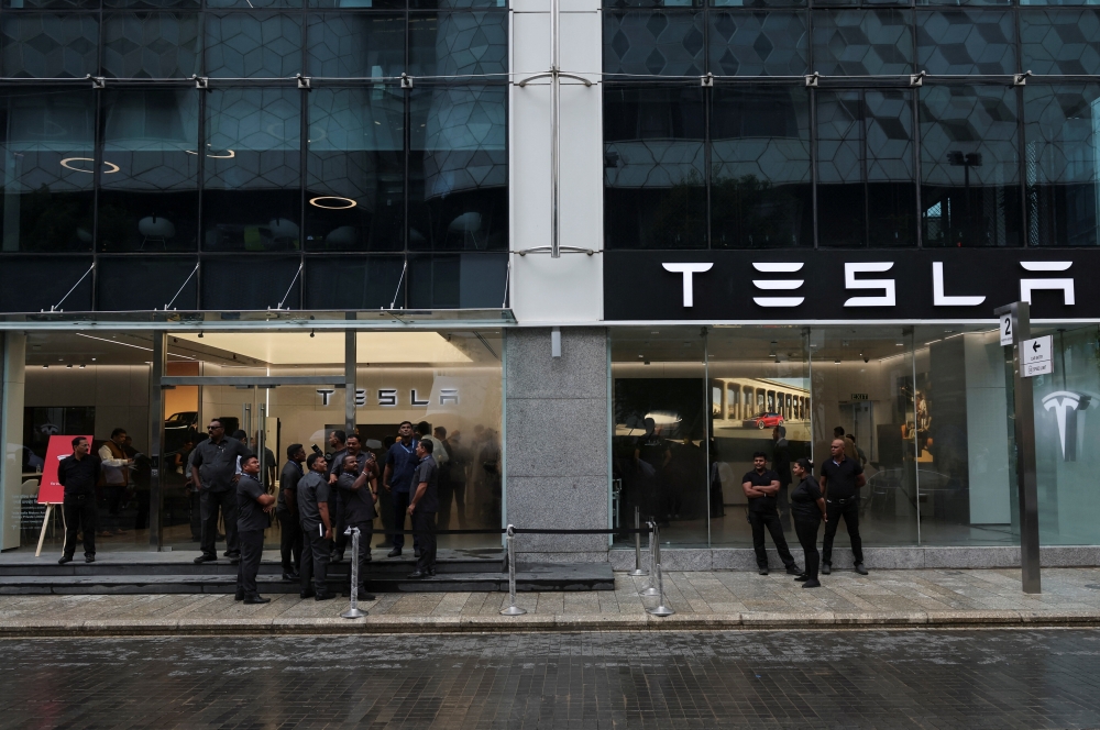 People are seen outside the Tesla showroom ahead of its opening in Mumbai, India, July 15, 2025. REUTERS/Francis Mascarenhas
