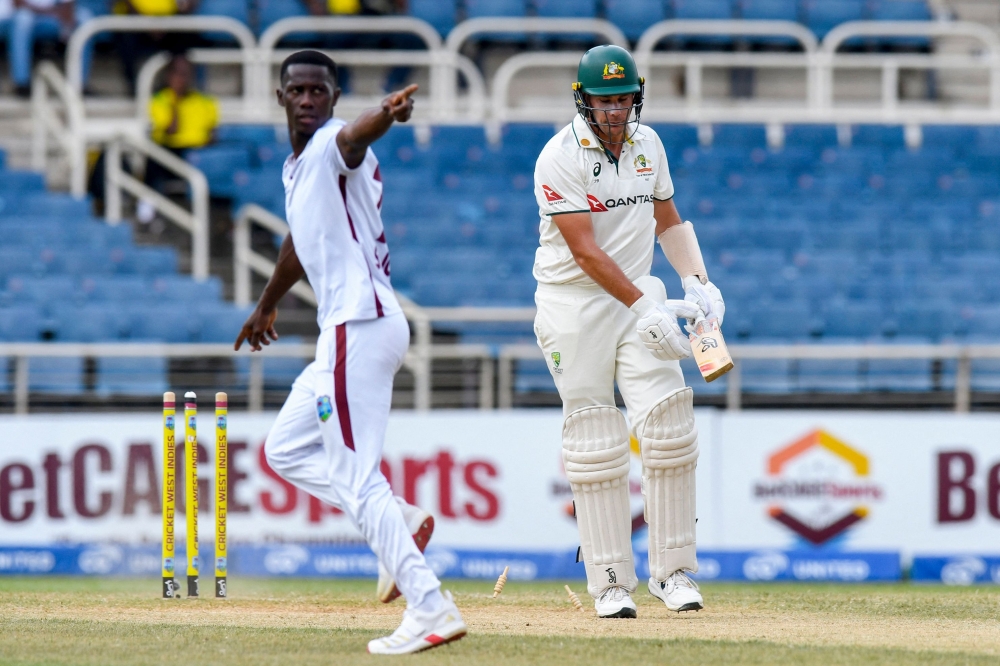Scott Boland (R) of Australia reacts after being bowled by Shamar Joseph (L) of West Indies. — AFP