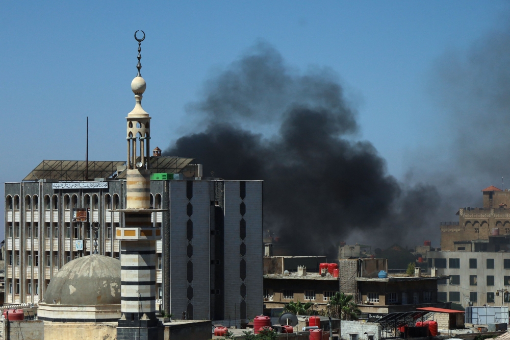 Smoke billows during clashes in the predominantly city of Sweida