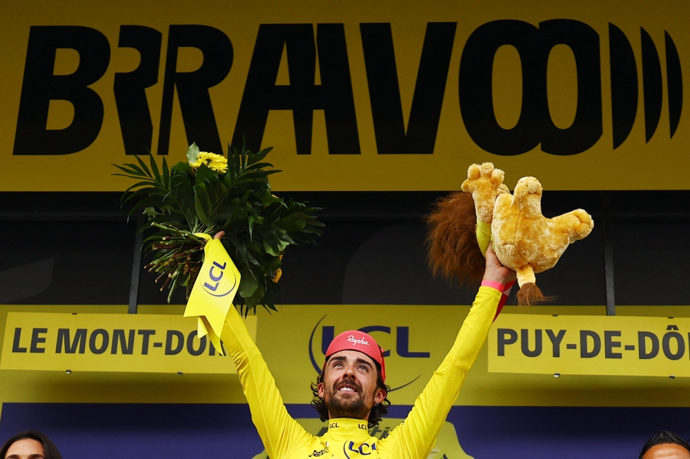 Cycling - Tour de France - Stage 10 - Ennezat to Mont-Dore - Ennezat, France - July 14, 2025 EF Education - EasyPost's Ben Healy celebrates on the podium wearing the yellow jersey after stage 10 REUTERS/Sarah Meyssonnier
