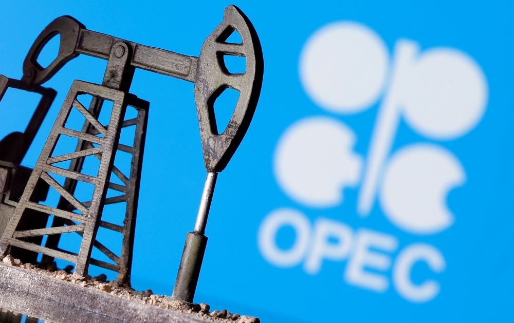 A 3D printed oil pump jack is seen in front of displayed Opec logo in this illustration picture. — Reuters