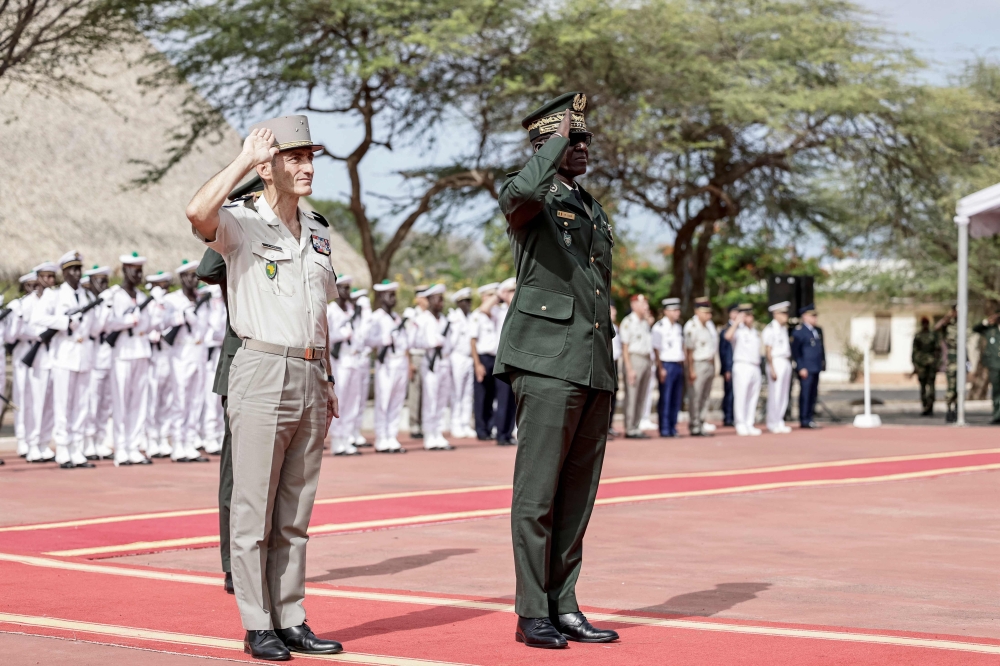 Senegal's Chief of General Staff, General Mbaye Cisse (R), and France's General Pascal Ianni, who commands France's troops in Africa, salute as the Senegalese flag is raised during a ceremony where France will return Camp Geille, and its airfield at Dakar airport, in Dakar. - AFP
 
