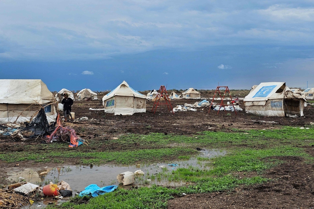 Mud covers the ground around tents at the Abu Al Naja camp for displaced Sudanese in the eastern Gedaref State. - AFP

