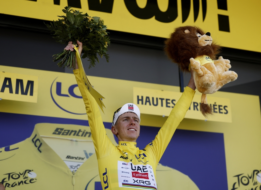  UAE Team Emirates XRG's Tadej Pogacar celebrates on the podium wearing the yellow jersey after winning stage 12. — Reuters