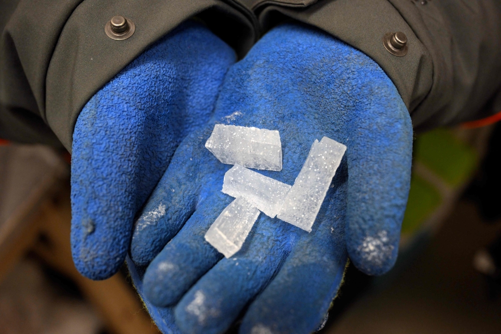 Belgian scientists holds blue ice samples in a laboratory in Brussels. - AFP  