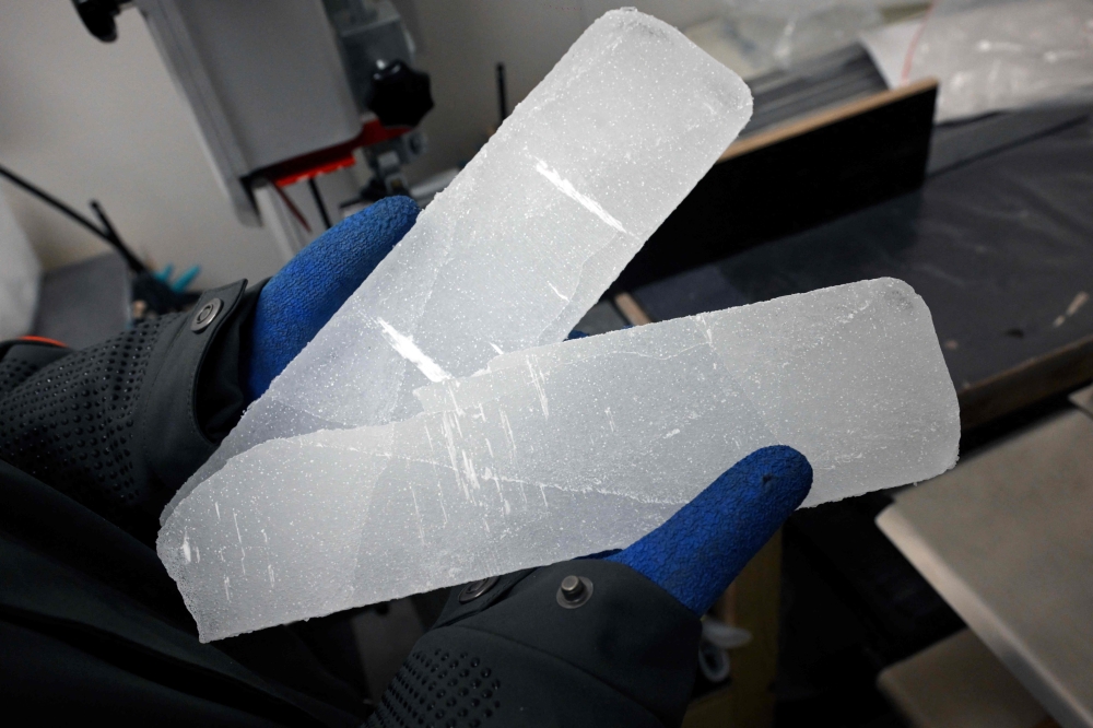 A Belgian scientist handles blue ice samples in a laboratory in Brussels. - AFP
