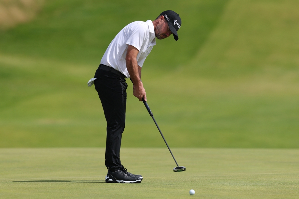 Brian Harman of the US putts on the 12th green during the second round. — Reuters