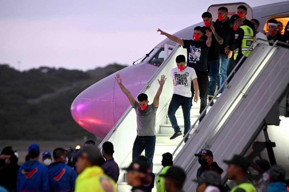 Venezuelan migrants get off a plane at Simon Bolivar International Airport in Maiquetia. — AFP