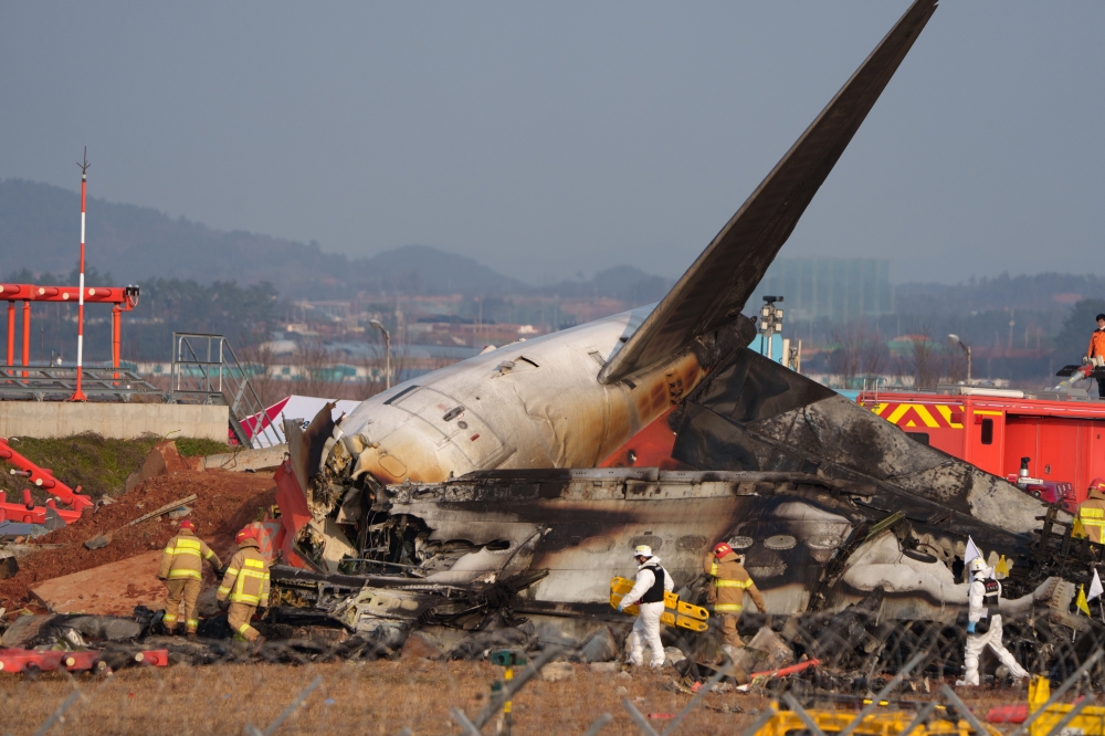 Firefighters and investigators at the scene of the Jeju Air plain which crashed in Muan International Airport in Muan, South Jeolla Province on Dec. 29, 2024. (Chang W. Lee/The New York Times)