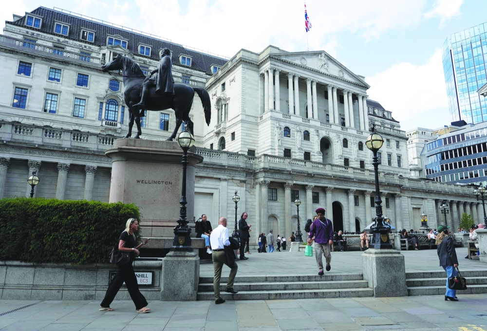 People walk outside the Bank of England building in London. — Reuters