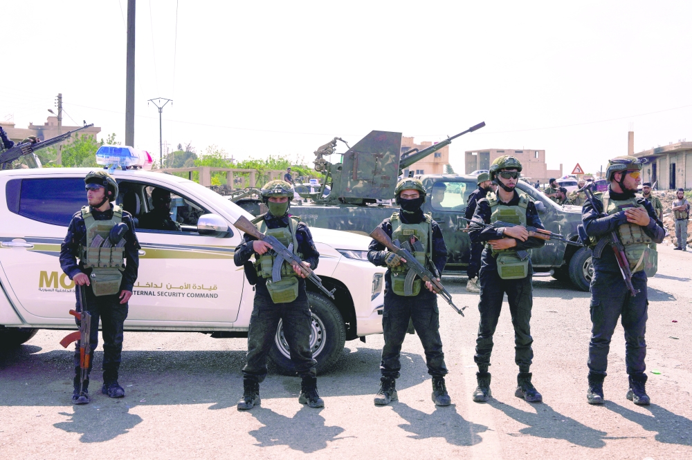 Members of Internal Security Forces hold guns at an Internal Security Forces' checkpoint, in Sweida. — Reuters