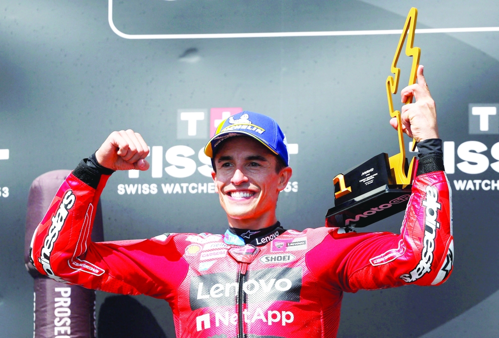 Ducati Lenovo Team’s Marc Marquez celebrates with a trophy on the podium after winning the MotoGP race. — Reuters