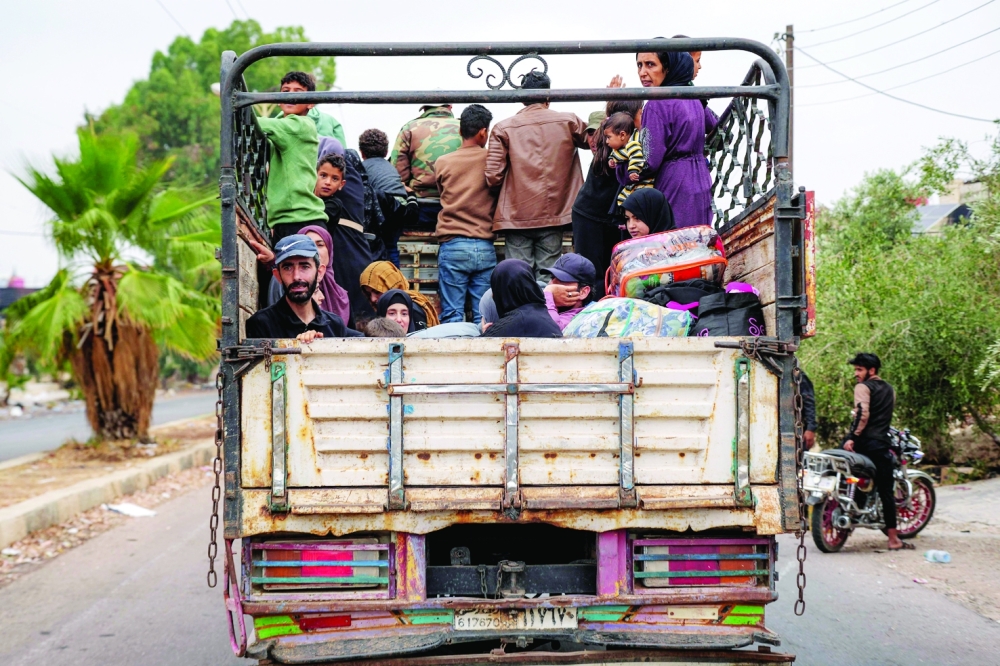 Evacuating Bedouins ride in the back of a truck stopping at a security checkpoint in Taara. — AFP
