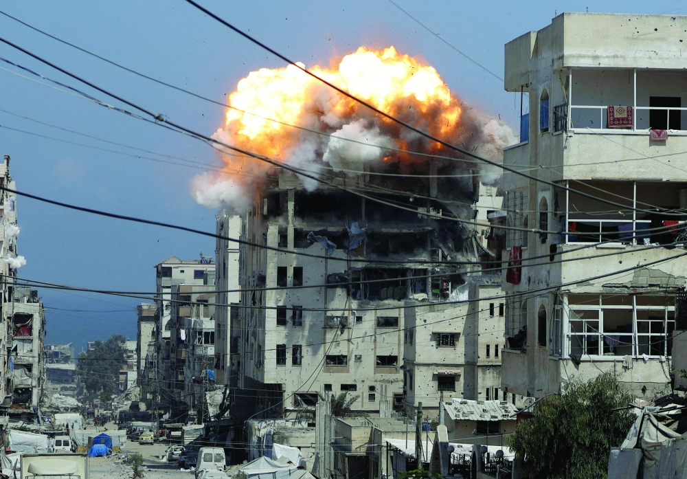 Smoke and flames rise from a residential building hit by an Israeli strike, in Gaza City. — Reuters