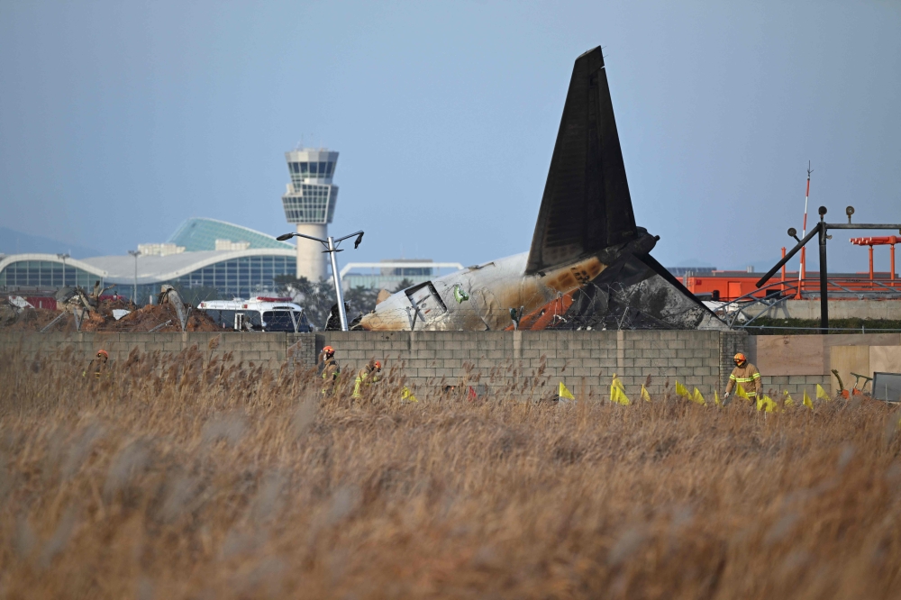 Recovery teams work at the scene where a Jeju Air Boeing 737-800 series aircraft crashed