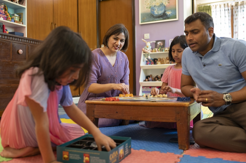 Himani Dalmia, second from left, and Akash Premsen, right, with their daughters Yamini and Devika at their home in New Delhi, June 1, 2025. (Saumya Khandelwal/The New York Times)