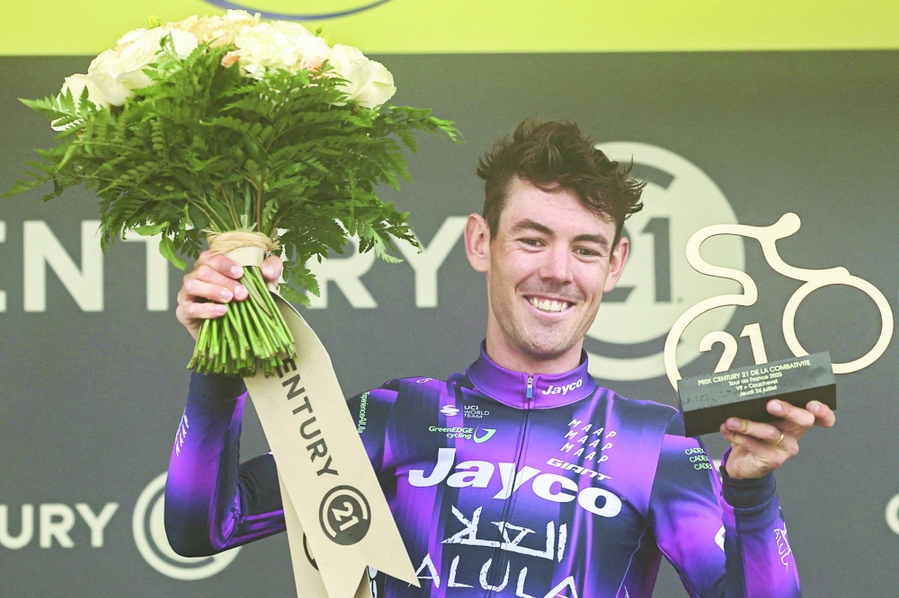 Team Jayco AlUla team's Australian rider Ben O'Connor celebrates on the podium after winning the 18th stage. — AFP