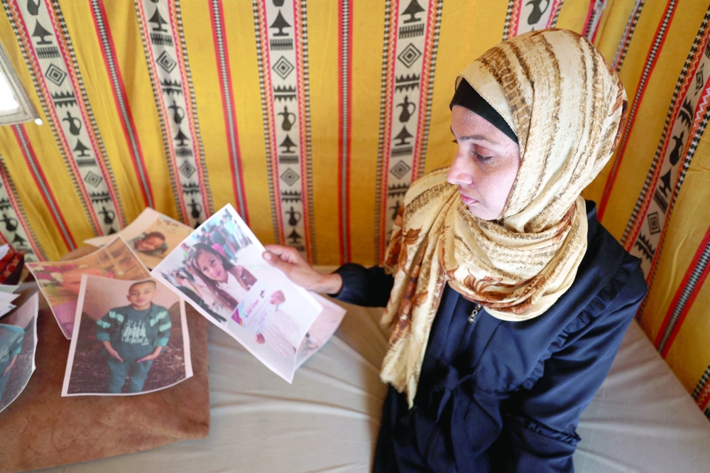 
Displaced Palestinian woman Amal Bakron holds a picture of her daughter Olina, who was killed in an Israeli strike, according to the family, at her tent in Gaza City. — Reuters 