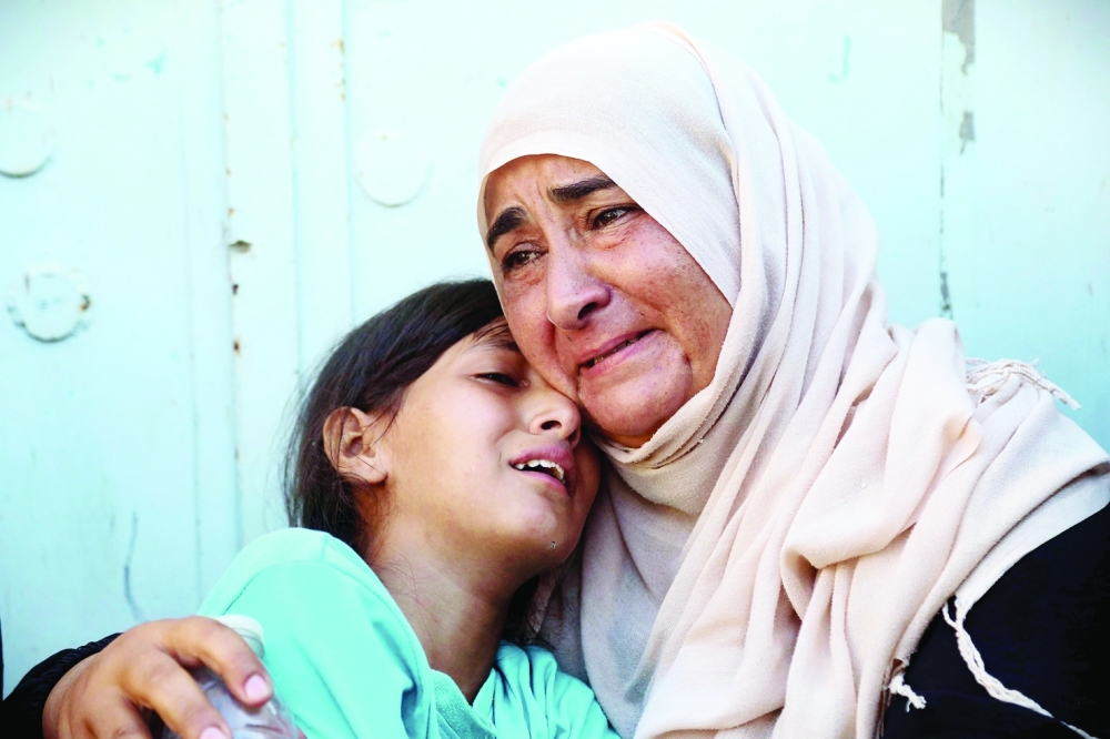 A woman and a child react after identifying the body of a family member at the Nasser Hospital, among Palestinians killed in Israeli strikes on the Al Mawasi refugee camp and the eastern neighbourhoods of Khan Yunis in Gaza Strip. -  AFP