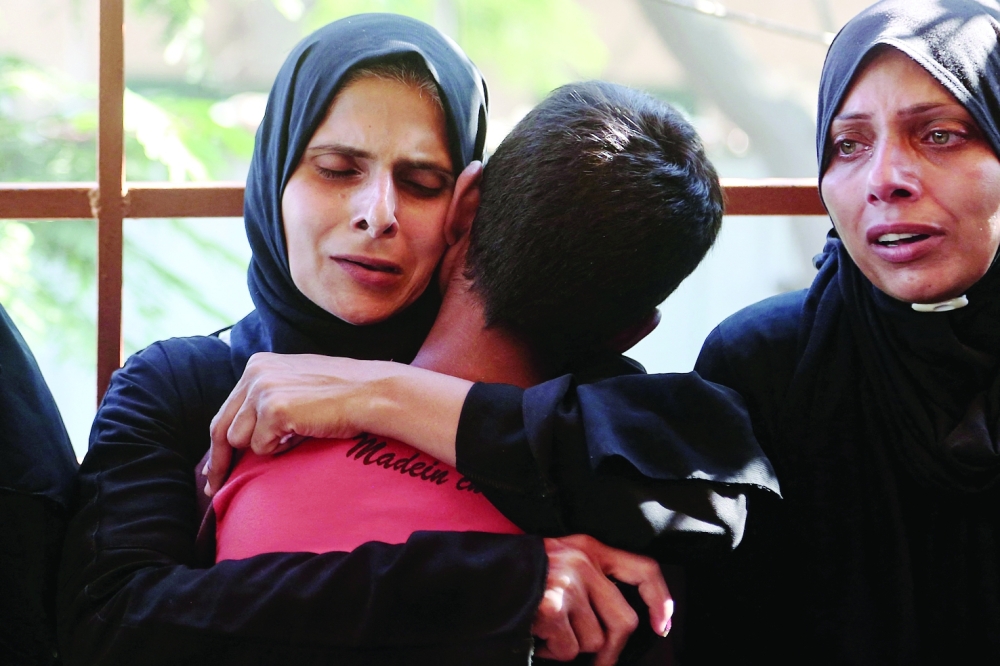 
A woman hugs a child after identifying the body of a family member at the Nasser Hospital, among Palestinians killed in Israeli strikes on the Al Mawasi refugee camp and the eastern neighbourhoods of Khan Yunis in Gaza Strip. — AFP 