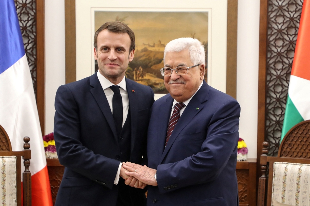 (FILES) French President Emmanuel Macron (L) shakes hands with Palestinian President Mahmoud Abbas at his headquarters in the West Bank city of Ramallah, on January 22, 2020.  French President said on July 24, 2025, his country would formally recognise a Palestinian state during a UN meeting in September, the most powerful European nation to announce such a move.