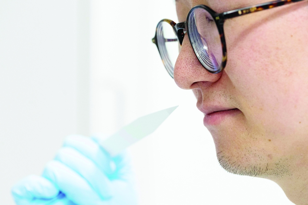 Junior perfumer Shangyun Lyu smells a smell strip which is used to evaluate fragrances at the Symrise company in Holzminden, central Germany, on July 8, 2025. Smell, a powerful sense that triggers emotions and memories, often decides which food, cleaning or personal hygiene product ends up in the shopping cart. At Symrise's headquarters in Holzminden, each day at the company's in-house perfumery school begins the same way: sniffing out scents from dozens of tiny bottles while blindfolded.