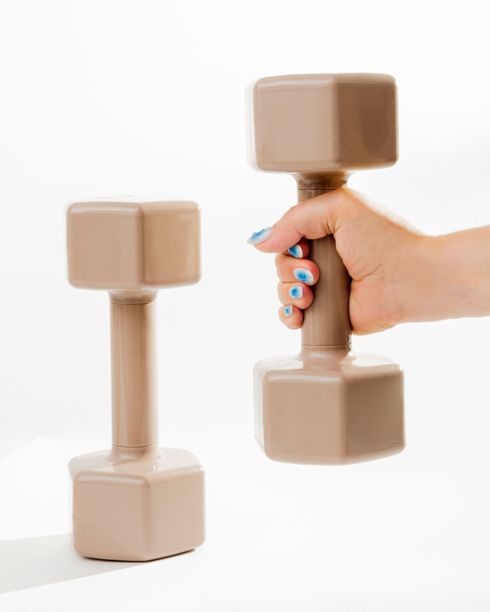 A hand grasps a beige hand weight in New York on July 18, 2025. (Eric Helgas/The New York Times)