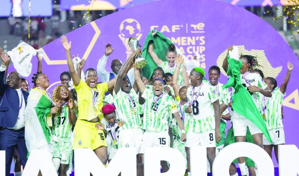 Nigeria women players celebrate on the podium after winning the WAFCON title against Morocco. — AFP